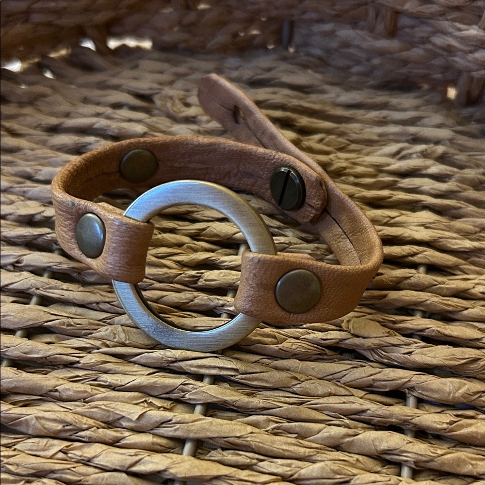 Giving Bracelets Grounding Bracelet featuring a leather band with central metal